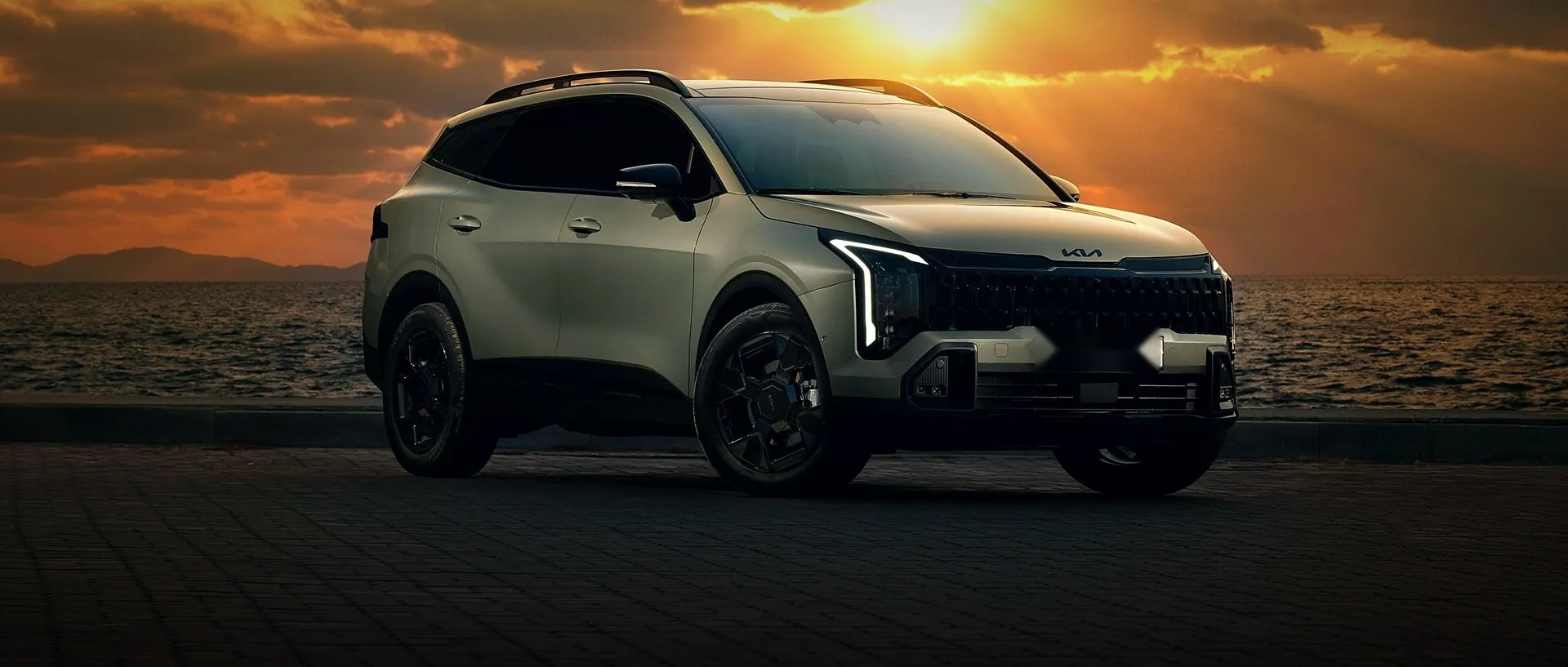 Kia Sportage parked by the water at sunset
